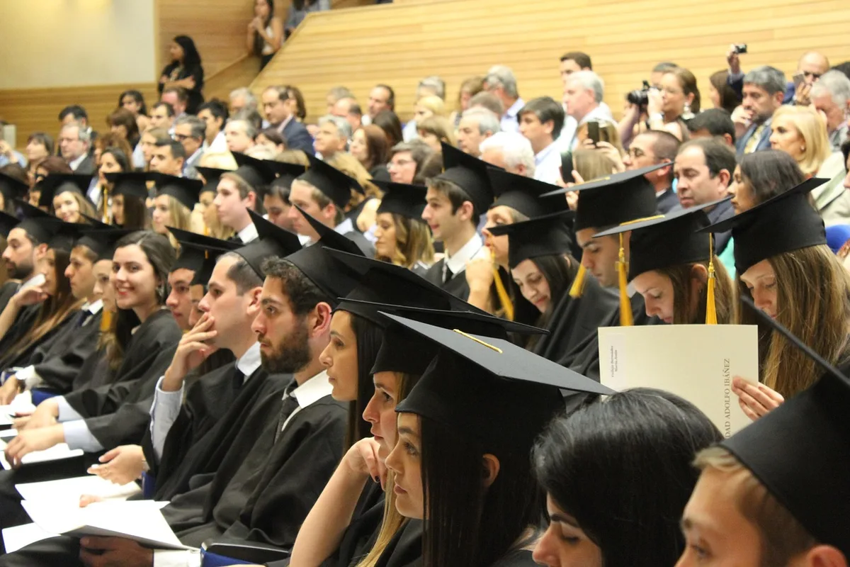 Close-up of hands holding a diploma certificate next to an open law textbook on a table